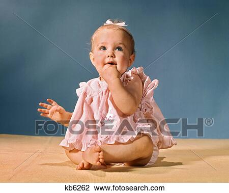 1960s LITTLE BABY GIRL SITTING WEARING PINK DRESS AND WHITE HAIR RIBBON LOOKING UPWARD View Large Photo Image Stock Image - 1960s LITTLE BABY GIRL SITTING WEARING PINK DRESS AND WHITE HAIR RIBBON LOOKING UPWARD. Fotosearch
