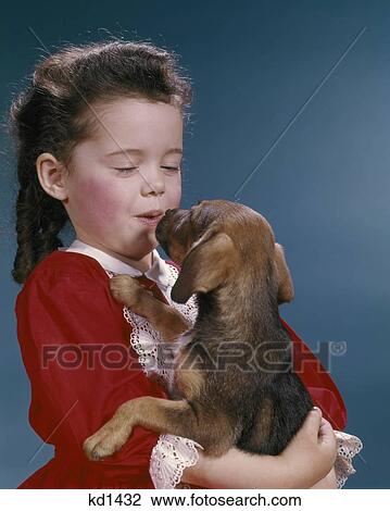 Stock Image - 1960S Little Girl Kissing Her Beagle Puppy. Fotosearch