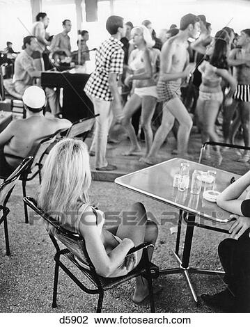 1960s LONG BLONDE HAIR WOMAN SITTING WATCHING GROUP OF YOUNG SPRING BREAK TEENS DANCING WEARING BEACH BATHING SUITS SEASIDE View Large Photo Image Stock Image - 1960s LONG BLONDE HAIR WOMAN SITTING WATCHING GROUP OF YOUNG SPRING BREAK TEENS DANCING WEARING BEACH BATHING SUITS SEASIDE. Fotosearch