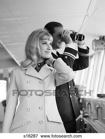 Stock Photo - 1960S Man Officer In Uniform Using Binoculars And Stylish Blond Woman Standing Together On Bridge Of A Cruise Ship. Fotosearch