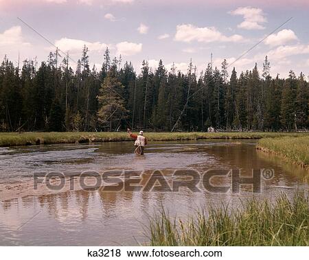 1960S Man Standing Middle Stream Fly Fishing River Forest Wilderness View Large Photo Image Stock Photo - 1960S Man Standing Middle Stream Fly Fishing River Forest Wilderness. Fotosearch