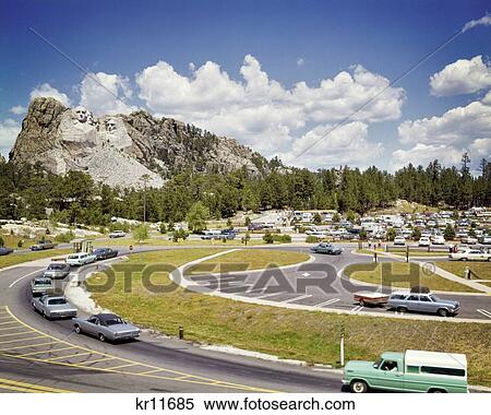 1960s MOUNT RUSHMORE NATIONAL MEMORIAL PARKING LOT CARS FOREGROUND SCULPTURE IN BACKGROUND BLACK HILLS KEYSTONE SOUTH DAKOTA USA View Large Photo Image Stock Photography - 1960s MOUNT RUSHMORE NATIONAL MEMORIAL PARKING LOT CARS FOREGROUND SCULPTURE IN BACKGROUND BLACK HILLS KEYSTONE SOUTH DAKOTA USA. Fotosearch