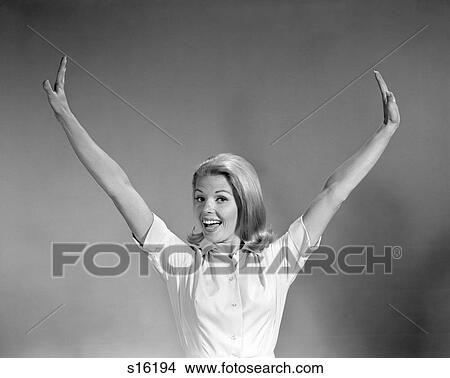 1960s PORTRAIT SMILING HAPPY BLOND WOMAN STRETCHING ARMS OUT AND UP ABOVE HEAD LOOKING AT CAMERA View Large Photo Image Picture - 1960s PORTRAIT SMILING HAPPY BLOND WOMAN STRETCHING ARMS OUT AND UP ABOVE HEAD LOOKING AT CAMERA. Fotosearch