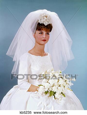1960s PORTRAIT WOMAN BRIDE IN SIMPLE WHITE WEDDING GOWN HOLDING WHITE FLOWER BOUQUET View Large Photo Image Stock Photography - 1960s PORTRAIT WOMAN BRIDE IN SIMPLE WHITE WEDDING GOWN HOLDING WHITE FLOWER BOUQUET. Fotosearch