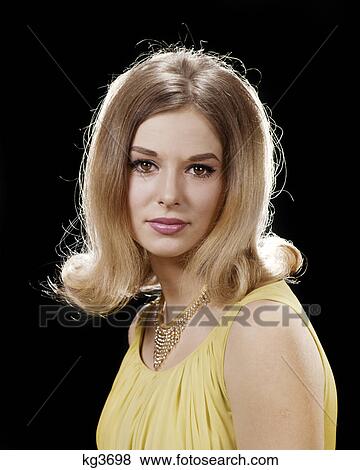 Stock Photo - 1960s PORTRAIT WOMAN LOOKING AT CAMERA BLOND BOUFFANT HAIR STYLE YELLOW DRESS GOLD RHINESTONE NECKLACE. Fotosearch