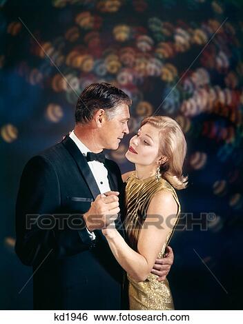 1960s ROMANTIC MATURE MIDDLE AGED COUPLE MAN WOMAN IN FORMAL ATTIRE EMBRACING DANCING View Large Photo Image Stock Photograph - 1960s ROMANTIC MATURE MIDDLE AGED COUPLE MAN WOMAN IN FORMAL ATTIRE EMBRACING DANCING. Fotosearch