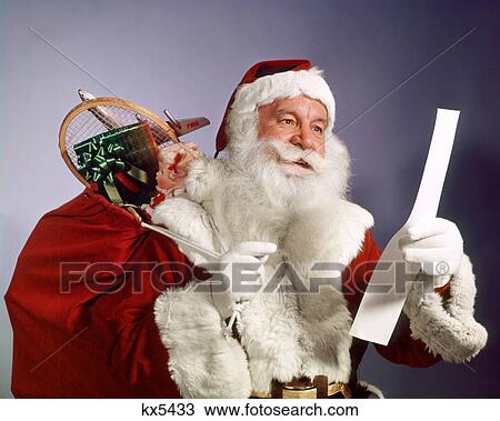 1960s SANTA CLAUS READING THE LIST OF NAUGHTY & NICE SMILING CARRY BAG OF TOYS View Large Photo Image Stock Image - 1960s SANTA CLAUS READING THE LIST OF NAUGHTY & NICE SMILING CARRY BAG OF TOYS. Fotosearch