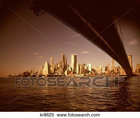 1960s SKYLINE UNDER BROOKLYN BRIDGE CONSTRUCTION CRANE OF WTC WORLD TRADE CENTER VISIBLE DOWNTOWN MANHATTAN NYC USA View Large Photo Image Stock Photography - 1960s SKYLINE UNDER BROOKLYN BRIDGE CONSTRUCTION CRANE OF WTC WORLD TRADE CENTER VISIBLE DOWNTOWN MANHATTAN NYC USA. Fotosearch
