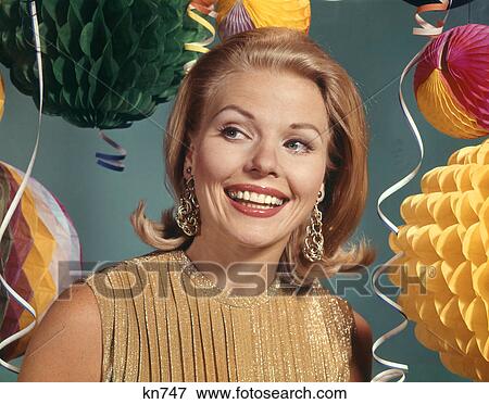1960s SMILING BLONDE WOMAN WEARING EVENING CLOTHES GOLD LAME BLOUSE AMONG PARTY BALLOONS AND STREAMERS View Large Photo Image Stock Photo - 1960s SMILING BLONDE WOMAN WEARING EVENING CLOTHES GOLD LAME BLOUSE AMONG PARTY BALLOONS AND STREAMERS. Fotosearch