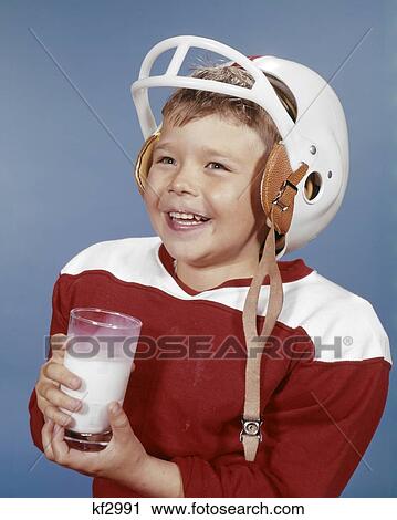 1960s SMILING BOY DRINKING MILK WEARING FOOTBALL UNIFORM AND HELMET RED JERSEY View Large Photo Image Stock Image - 1960s SMILING BOY DRINKING MILK WEARING FOOTBALL UNIFORM AND HELMET RED JERSEY. Fotosearch