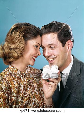 1960s SMILING COUPLE TOUCHING FOREHEADS LOOKING AT EACH OTHER HOLDING UP BABY SHOES View Large Photo Image Stock Image - 1960s SMILING COUPLE TOUCHING FOREHEADS LOOKING AT EACH OTHER HOLDING UP BABY SHOES. Fotosearch