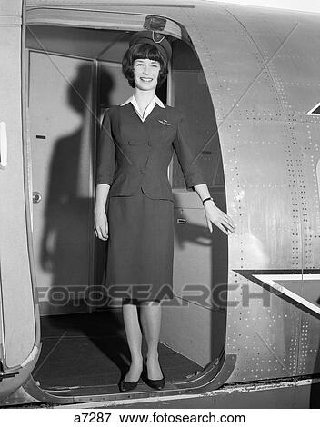 Stock Photo - 1960S Smiling Stewardess Standing In Doorway Of Airplane Looking At Camera . Fotosearch