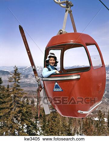 1960s SMILING WOMAN SKIER SITTING IN SKI LIFT GONDOLA LOOKING AT CAMERA SUGARLOAF MAINE USA View Large Photo Image Stock Photography - 1960s SMILING WOMAN SKIER SITTING IN SKI LIFT GONDOLA LOOKING AT CAMERA SUGARLOAF MAINE USA. Fotosearch