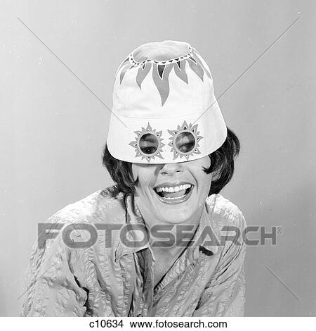 1960s SMILING WOMAN WEARING FUNNY WACKY SUN HAT WITH SUNSPOTS FOR EYEGLASSES LOOKING AT CAMERA View Large Photo Image Picture - 1960s SMILING WOMAN WEARING FUNNY WACKY SUN HAT WITH SUNSPOTS FOR EYEGLASSES LOOKING AT CAMERA. Fotosearch