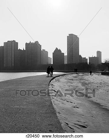 1960s TWO ANONYMOUS SILHOUETTED PEOPLE WALKING ALONG LAKE SHORE CHICAGO ILLINOIS USA View Large Photo Image Stock Image - 1960s TWO ANONYMOUS SILHOUETTED PEOPLE WALKING ALONG LAKE SHORE CHICAGO ILLINOIS USA. Fotosearch