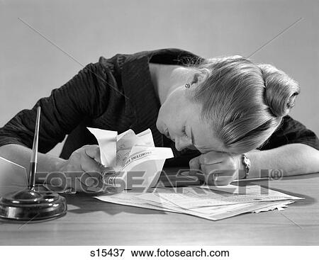 1960s UNHAPPY WOMAN SLUMPED ACROSS DESK OVER PAPERS BILLS GRASPING SOME IN HAND View Large Photo Image Stock Photo - 1960s UNHAPPY WOMAN SLUMPED ACROSS DESK OVER PAPERS BILLS GRASPING SOME IN HAND. Fotosearch