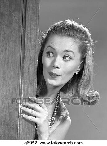 1960s WOMAN PEEKING AROUND DOOR WITH FUNNY FACIAL EXPRESSION View Large Photo Image Stock Image - 1960s WOMAN PEEKING AROUND DOOR WITH FUNNY FACIAL EXPRESSION. Fotosearch