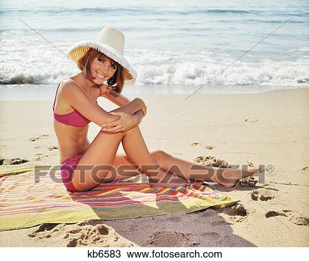 1960s WOMAN WEARING PINK BIKINI LOOKING AT CAMERA WEARING STRAW SUN HAT SITTING ON BEACH TOWEL BY SURF View Large Photo Image Stock Image - 1960s WOMAN WEARING PINK BIKINI LOOKING AT CAMERA WEARING STRAW SUN HAT SITTING ON BEACH TOWEL BY SURF. Fotosearch