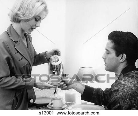 Stock Image - 1960S Young Couple Wearing Robes Having Morning Coffee From Electric Percolator Coffee Pot. Fotosearch