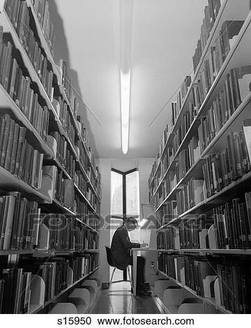 1960s YOUNG MAN STUDENT READING STUDYING AMONG LIBRARY BOOK STACKS View Large Photo Image Stock Image - 1960s YOUNG MAN STUDENT READING STUDYING AMONG LIBRARY BOOK STACKS. Fotosearch