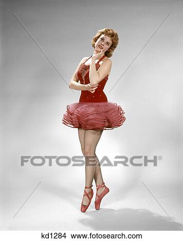 Picture - 1960s YOUNG SMILING BALLERINA DANCER RED TUTU POINT SHOES FISHNET STOCKINGS RED HAIR. Fotosearch