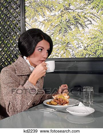 1960s YOUNG WOMAN DRESSED UP TWEED JACKET SIPPING DRINK COFFEE EATING DELI LUNCH SANDWICH View Large Photo Image Stock Photo - 1960s YOUNG WOMAN DRESSED UP TWEED JACKET SIPPING DRINK COFFEE EATING DELI LUNCH SANDWICH. Fotosearch