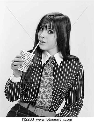 1960S Young Woman Mod Fashion Drinking From Paper Cup Straw Striped Shirt Print Necktie Looking At Camera View Large Photo Image Stock Image - 1960S Young Woman Mod Fashion Drinking From Paper Cup Straw Striped Shirt Print Necktie Looking At Camera. Fotosearch