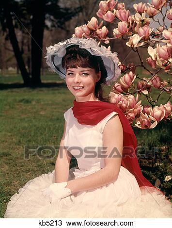 1960s YOUNG WOMAN SITTING BY BLOSSOMING MAGNOLIA TREE WEARING SPRINGTIME HAT RED SCARF WHITE GLOVES AND DRESS LOOKING AT CAMERA View Large Photo Image Stock Image - 1960s YOUNG WOMAN SITTING BY BLOSSOMING MAGNOLIA TREE WEARING SPRINGTIME HAT RED SCARF WHITE GLOVES AND DRESS LOOKING AT CAMERA. Fotosearch
