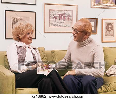 1970s 1980s RETIRED COUPLE SITTING COUCH WOMAN DOING EMBROIDERY View Large Photo Image Stock Image - 1970s 1980s RETIRED COUPLE SITTING COUCH WOMAN DOING EMBROIDERY. Fotosearch