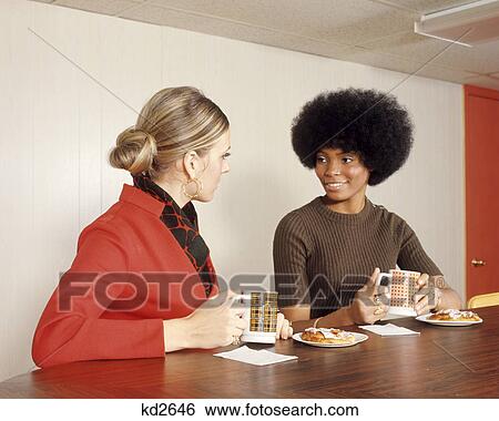 1970s AFRICAN AMERICAN AND CAUCASIAN WOMAN HAVING COFFEE DANISH COFFEE SHOP COUNTER View Large Photo Image Stock Photograph - 1970s AFRICAN AMERICAN AND CAUCASIAN WOMAN HAVING COFFEE DANISH COFFEE SHOP COUNTER. Fotosearch