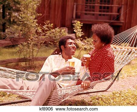 1970S African American Couple Man Woman Reclining In Hammock Drinking Beer Outside View Large Photo Image Stock Photograph - 1970S African American Couple Man Woman Reclining In Hammock Drinking Beer Outside. Fotosearch