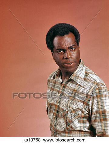 1970s AFRICAN AMERICAN MAN WEARING PLAID SHIRT LOOKING AT CAMERA WITH ANGRY MEAN QUESTIONING OR INQUISITIVE FACIAL EXPRESSION View Large Photo Image Stock Photo - 1970s AFRICAN AMERICAN MAN WEARING PLAID SHIRT LOOKING AT CAMERA WITH ANGRY MEAN QUESTIONING OR INQUISITIVE FACIAL EXPRESSION. Fotosearch