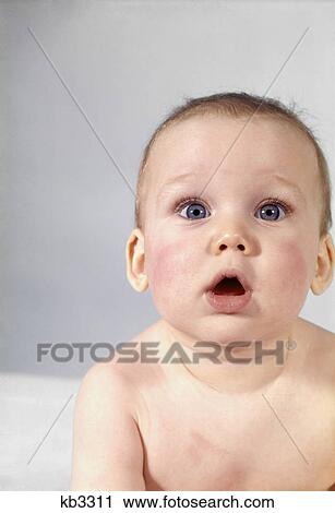 Stock Image - 1970s BABY HEAD PORTRAIT SHOCKED SURPRISED MOUTH OPEN EXPRESSION LOOKING AT CAMERA. Fotosearch