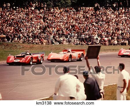 1970s CAR AUTO RACING 3 RED CARS TRACK MAN PIT HOLDING UP SIGN TO DRIVERS View Large Photo Image Stock Photo - 1970s CAR AUTO RACING 3 RED CARS TRACK MAN PIT HOLDING UP SIGN TO DRIVERS. Fotosearch
