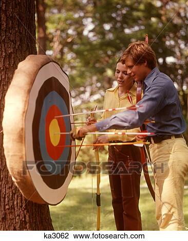 1970S Couple Archery Target Bows Arrows Targets Archers Couples Man Woman Men Women Sports Bow Sport View Large Photo Image Stock Image - 1970S Couple Archery Target Bows Arrows Targets Archers Couples Man Woman Men Women Sports Bow Sport. Fotosearch
