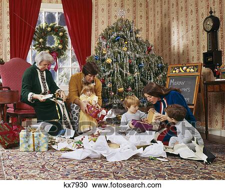1970s FAMILY OPENING PRESENTS CHRISTMAS MORNING AROUND THE TREE View Large Photo Image Stock Image - 1970s FAMILY OPENING PRESENTS CHRISTMAS MORNING AROUND THE TREE. Fotosearch