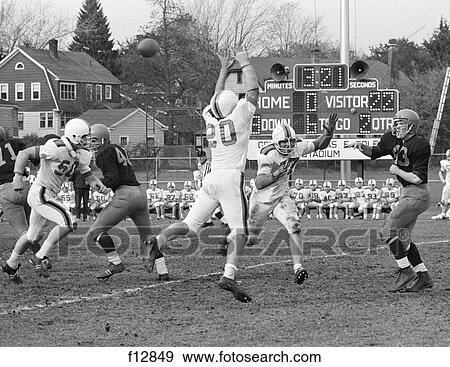 1970s HIGH SCHOOL FOOTBALL GAME SCORE BOARD IN BACKGROUND RECEIVING PASS UNIFORM View Large Photo Image Stock Photo - 1970s HIGH SCHOOL FOOTBALL GAME SCORE BOARD IN BACKGROUND RECEIVING PASS UNIFORM. Fotosearch