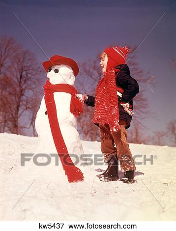 1970s LAUGHING BOY BUILDING SNOWMAN BOTH WEARING RED KNIT SCARVES IN COLD WINTER SNOW View Large Photo Image Stock Photo - 1970s LAUGHING BOY BUILDING SNOWMAN BOTH WEARING RED KNIT SCARVES IN COLD WINTER SNOW. Fotosearch
