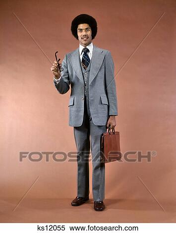 1970s SMILING AFRICAN AMERICAN MAN THREE PIECE SUIT BRIEFCASE LOOKING AT CAMERA POINTING GESTURING WITH EYEGLASSES View Large Photo Image Stock Photography - 1970s SMILING AFRICAN AMERICAN MAN THREE PIECE SUIT BRIEFCASE LOOKING AT CAMERA POINTING GESTURING WITH EYEGLASSES. Fotosearch