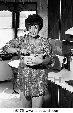 1970S Smiling Middle Aged Housewife With Mixing Bowl In Kitchen Looking At Camera View Large Photo Image Stock Photograph - 1970S Smiling Middle Aged Housewife With Mixing Bowl In Kitchen Looking At Camera. Fotosearch