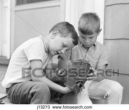 1970S Two Boys Seriously Inspecting New Leather Baseball Mitt Sitting On Porch View Large Photo Image Stock Image - 1970S Two Boys Seriously Inspecting New Leather Baseball Mitt Sitting On Porch. Fotosearch