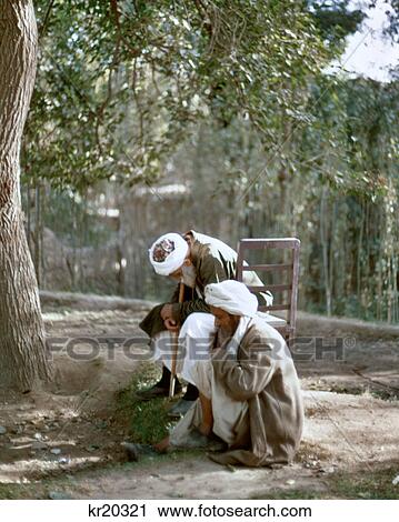 1970s TWO ELDER AFGHANI MEN SITTING IN SHADE OF A TREE View Large Photo Image Stock Image - 1970s TWO ELDER AFGHANI MEN SITTING IN SHADE OF A TREE. Fotosearch