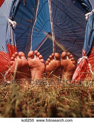 Stock Photography - 1970S Two Pair Bare Feet Sticking Out Tent Grass. Fotosearch