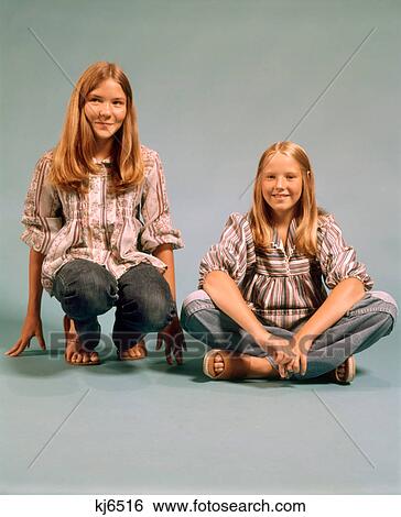 1970s TWO TEEN GIRLS SISTERS SMILING WEARING PEASANT SHIRTS BLUE JEANS SITTING AND KNEELING TOGETHER LOOKING AT CAMERA View Large Photo Image Stock Photograph - 1970s TWO TEEN GIRLS SISTERS SMILING WEARING PEASANT SHIRTS BLUE JEANS SITTING AND KNEELING TOGETHER LOOKING AT CAMERA. Fotosearch