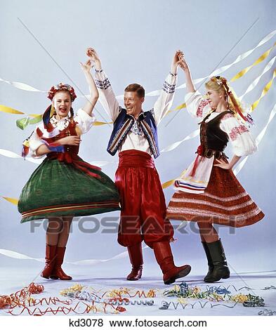 Stock Photo - 1970S Two Young Women And One Man In Traditional Clothes Dancing Polish Polka. Fotosearch