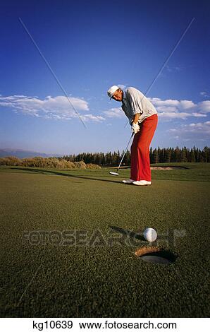 1980s 1990s MAN WEARING BRIGHT RED TROUSERS PUTTING ON GOLF GREEN BALL ON LIP OF HOLE View Large Photo Image Stock Photo - 1980s 1990s MAN WEARING BRIGHT RED TROUSERS PUTTING ON GOLF GREEN BALL ON LIP OF HOLE. Fotosearch