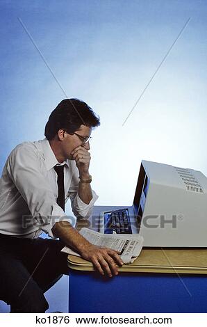1980s MAN SITTING AT COMPUTER LOOKING TIRED WORRIED View Large Photo Image Stock Photograph - 1980s MAN SITTING AT COMPUTER LOOKING TIRED WORRIED. Fotosearch