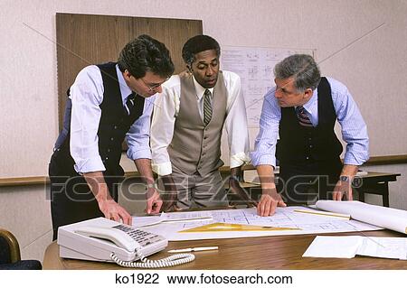 1980s THREE BUSINESSMEN LOOKING OVER BLUEPRINTS IN OFFICE View Large Photo Image Stock Image - 1980s THREE BUSINESSMEN LOOKING OVER BLUEPRINTS IN OFFICE. Fotosearch