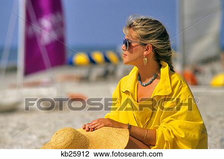 1980s WOMAN IN YELLOW JACKET SUNGLASSES HOLDING STRAW HAT SITTING ON BEACH View Large Photo Image Stock Image - 1980s WOMAN IN YELLOW JACKET SUNGLASSES HOLDING STRAW HAT SITTING ON BEACH. Fotosearch