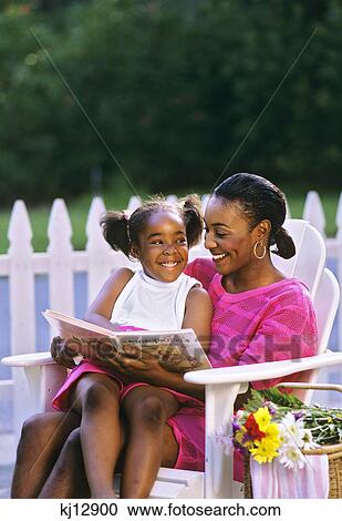 1990s MOTHER SITTING ON WHITE LAWN CHAIR WITH DAUGHTER ON HER LAP WITH BOOK View Large Photo Image Stock Image - 1990s MOTHER SITTING ON WHITE LAWN CHAIR WITH DAUGHTER ON HER LAP WITH BOOK. Fotosearch